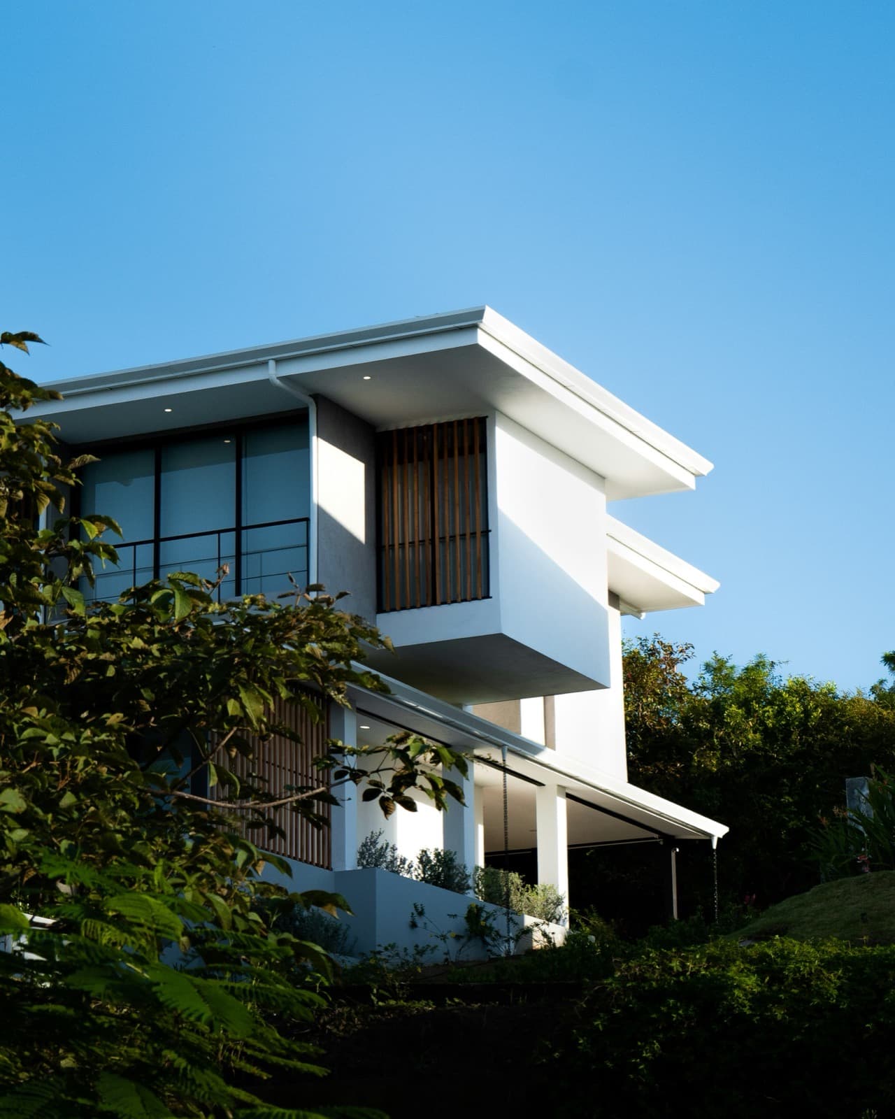 A modern house with timber slat screens and a covered outdoor terrace